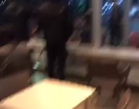 Hooded Man at Fast Food Restaurant Plays With Long Wooden Dowels Like They Are Swords