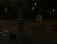 Man In Hoodie Headbutts White Sign at Night