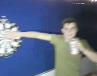 guy playing darts while friend has hand in the dart board 