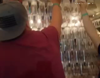 guy tries arranging bottles but gets pushed on top of them 