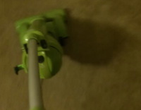 dog barks at green vacuum 