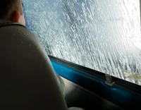 Guys open car window in drive thru car wash