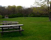 Man In White Sleevless Shirt And Glasses Tries to Jump Over Picnic Table But Racks Himself