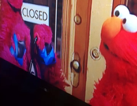 Kid Watches Sesame Street And Sits On Black Dog