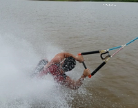 Barefoot waterskiing guy wipe out after tricks