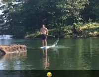 Guy on paddleboard gets tackled by friend