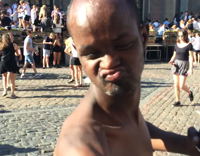 Black shirtless skinny homeless guy dancing to music